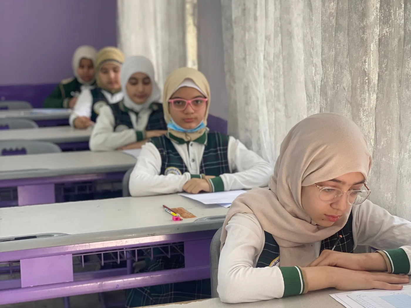 Students working through an exam paper at their desks